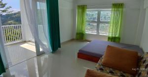 a bedroom with a bed and a balcony with windows at Rumah Kina Putih in Bandung