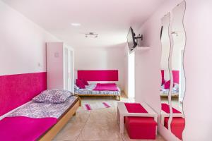 a room with two beds and pink walls at Wera Domki in Jastarnia