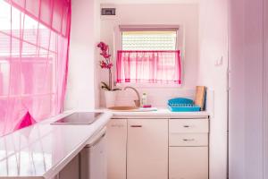 a white kitchen with a sink and a window at Wera Domki in Jastarnia +17 photos