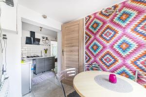eine Küche mit einem Tisch und einer farbenfrohen Wand in der Unterkunft Wera Domki in Jastarnia
