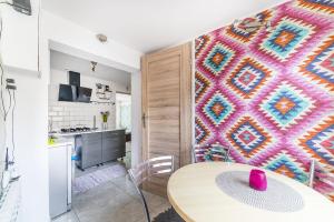 a kitchen with a table and a colorful wall at Wera Domki in Jastarnia