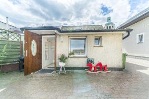 a house with a door and red chairs in front of it at Wera Domki in Jastarnia