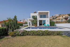 a villa with a swimming pool and a house at Punta Carnero - Villa de ensueño in Algeciras