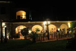 un grupo de personas sentadas en un restaurante por la noche en Villa Govi, en Diano Castello