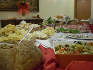 une table recouverte de beaucoup de différents types de nourriture dans l'établissement Nido Del Merlo, à Santomato 
