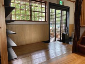 a room with a wooden floor and a staircase with windows at Riverside Hotel Karatsu Castle in Karatsu