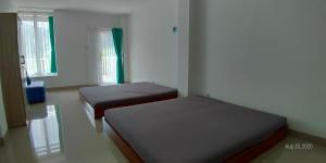 Un pat sau paturi într-o cameră la Rumah Kina Putih