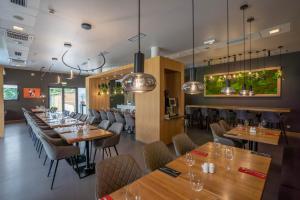 una sala da pranzo con tavoli e sedie in legno di Ibis Hotel Plzeň a Plzeň