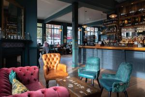 een bar met stoelen, een bank en een tafel bij The Station Hotel in Londen