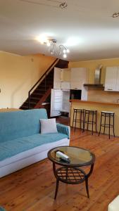ein Wohnzimmer mit einem blauen Sofa und einem Tisch in der Unterkunft Torres Rojas Attico in Ivrea