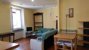 ein Wohnzimmer mit einem Sofa und einem Tisch in der Unterkunft Torres Rojas Attico in Ivrea