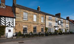 um grande edifício de tijolos com um relógio em The Black Swan - The Inn Collection Group em Helmsley