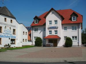 un grand bâtiment blanc avec un toit rouge dans l'établissement Pension zur Traube 3 Sterne, à Oberschwarzach