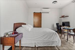 a bedroom with a bed and a desk and a table with chairs at Suite Loft Moderno Ubicación Inmejorable 104A in Querétaro