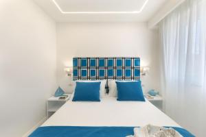 a bedroom with a blue and white bed with blue pillows at Gala Residence Villa Giovanna in Ravello