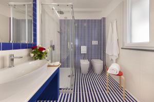 a blue and white bathroom with a sink and a shower at Gala Residence Villa Giovanna in Ravello