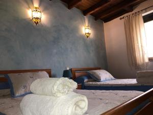 Sancti SpíritusにあるCasa rural Pérez Martínのベッドルーム1室(ベッド2台、壁に照明2つ付)