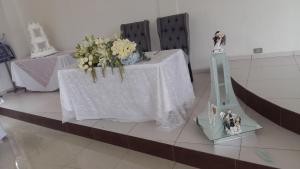 une table avec des fleurs et une mariée et un marié. dans l'établissement Hotel SanJo, à San José Iturbide