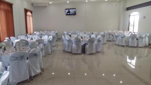 une salle remplie de tables et de chaises avec un tissu de table blanc dans l'établissement Hotel SanJo, à San José Iturbide