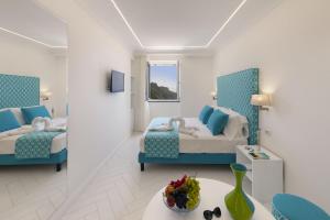 a hotel room with two beds and a table at Gala Residence Villa Giovanna in Ravello