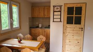 a kitchen with a table and a wooden door at Zawoja Chaty Górskie D1 in Zawoja +17 photos