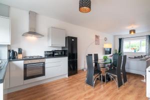 cocina y comedor con mesa y sillas en Mosh Aparthotel en Mánchester