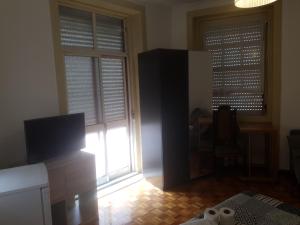 a living room with a television and two windows at Truz truz4 in Porto