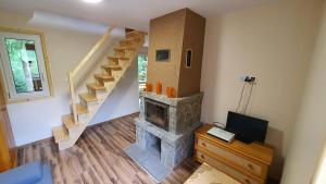 a living room with a fireplace and a staircase at Zawoja Chaty Górskie D1 in Zawoja