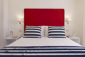 a bed with a red headboard and two blue and white pillows at Gala Residence Villa Giovanna in Ravello