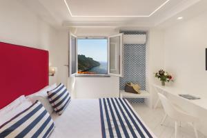 a bedroom with a bed and a desk and a window at Gala Residence Villa Giovanna in Ravello