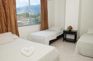 a room with two beds and a window at Hotel Recuerdos del Estadio in Medellín