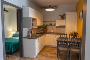 a kitchen with a small table and a kitchen with yellow walls at Moon Hostel Poznań in Poznań