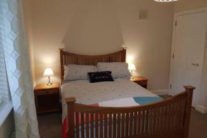 a bedroom with a wooden bed with two lamps at Faithlegg House Hotel Holiday Lodge in Waterford