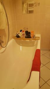 een badkamer met een bad met een rode handdoek erop bij Am-Berg Ferienwohnung in Bad kohlgrub in Bad Kohlgrub