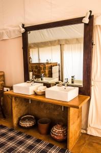a bathroom with two sinks and a large mirror at SUJÁN The Serai Jaisalmer in Jaisalmer