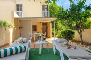 eine Terrasse mit 2 Liegestühlen und einem Tisch in der Unterkunft Bella in Alcúdia