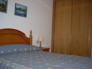 1 dormitorio con 1 cama y puerta de madera en La Coma De Alba, en Benasque