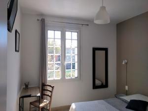 una camera con letto, finestra e sedia di Hotel Araur ad Agde
