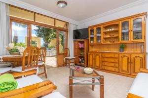 ein Wohnzimmer mit Holzschränken und einem Tisch in der Unterkunft Bella in Alcúdia