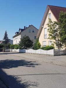 a house with a white fence next to a street at Tulpenoase in Neuendettelsau +5 photos