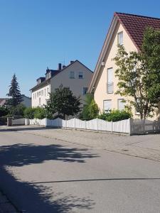 une maison avec une clôture blanche à côté d'une rue dans l'établissement Tulpenoase, à Neuendettelsau