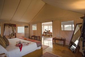 ジャイサルメールにあるSUJÁN The Serai Jaisalmerのベッドとダイニングルームのある寝室