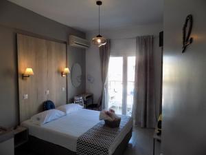 a bedroom with a bed and a large window at VANA Studios & Apartments in Limenaria