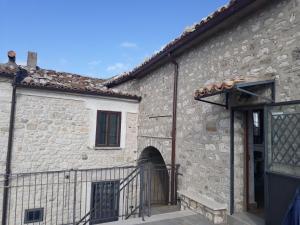 una vecchia casa in pietra con cancello e un edificio di Casetta nel borgo a Torrebruna