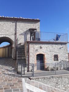 um edifício de pedra com uma escada e uma varanda em Casetta nel borgo em Torrebruna