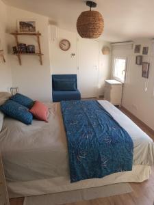 1 dormitorio con 1 cama grande y 1 silla azul en Beau duplex avec terrasse - Centre historique, en Aix-en-Provence
