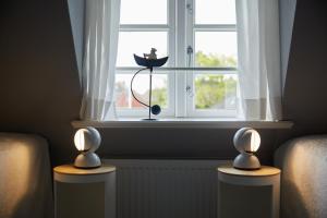 a window with two lamps in front of a window at FÖHRIENHAUS stilvolle 5 Sterne Einheiten in ruhiger Marschrandlage auf Föhr für Gäste, die das Besondere schätzen, gerne auch mit Hund in Midlum +126 photos