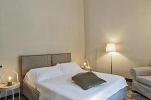- une chambre avec un lit, une chaise et une lampe dans l'établissement Via Roma Luxury Apartment by Wonderful Italy, à Gênes
