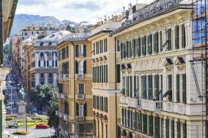 un edificio alto de color amarillo con ventanas en una calle de la ciudad en Via Roma Luxury Apartment by Wonderful Italy, en Génova