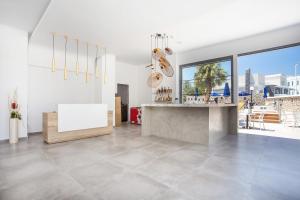 a white room with a counter and a large window at Moscha Hotel in Faliraki